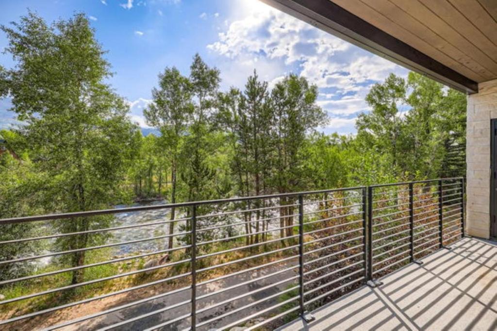 a balcony with a view of a river and trees at River West 822 in Silverthorne