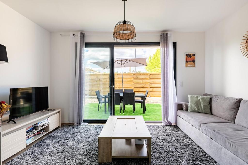 a living room with a couch and a table at Maison vacances à Labenne in Labenne