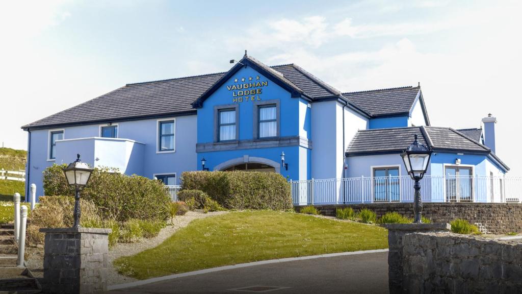 a blue house with a driveway in front of it at Vaughan Lodge Hotel in Lahinch