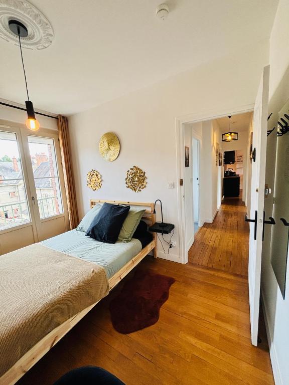 a bedroom with a large bed and a hallway at Le Victor Hugo in Gien