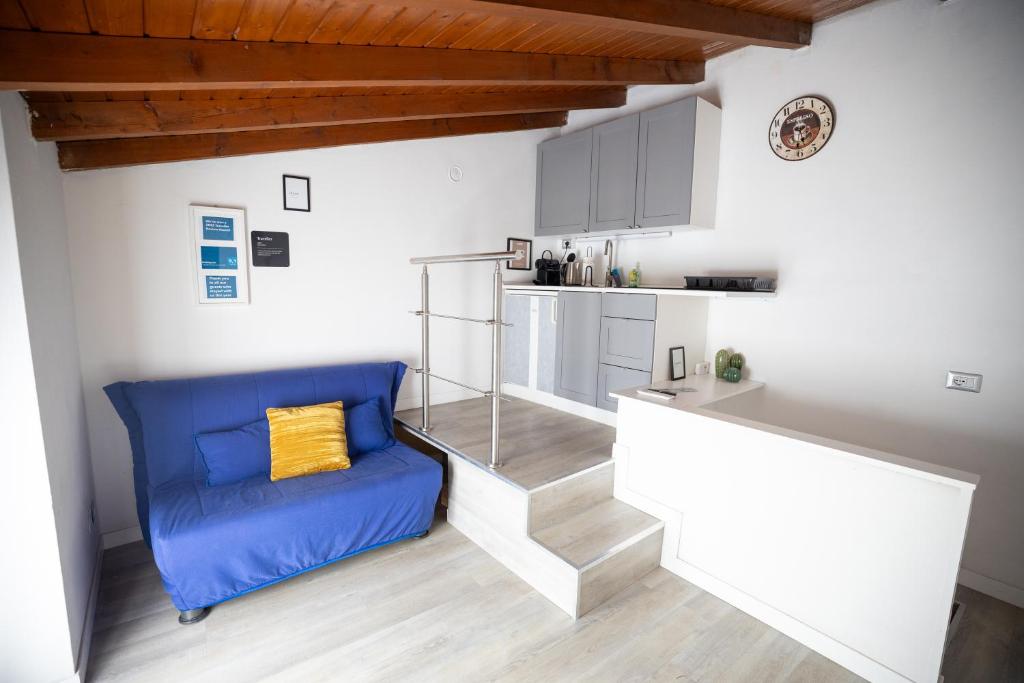 a blue couch in a room with a kitchen at Duplex San Fedele in Como