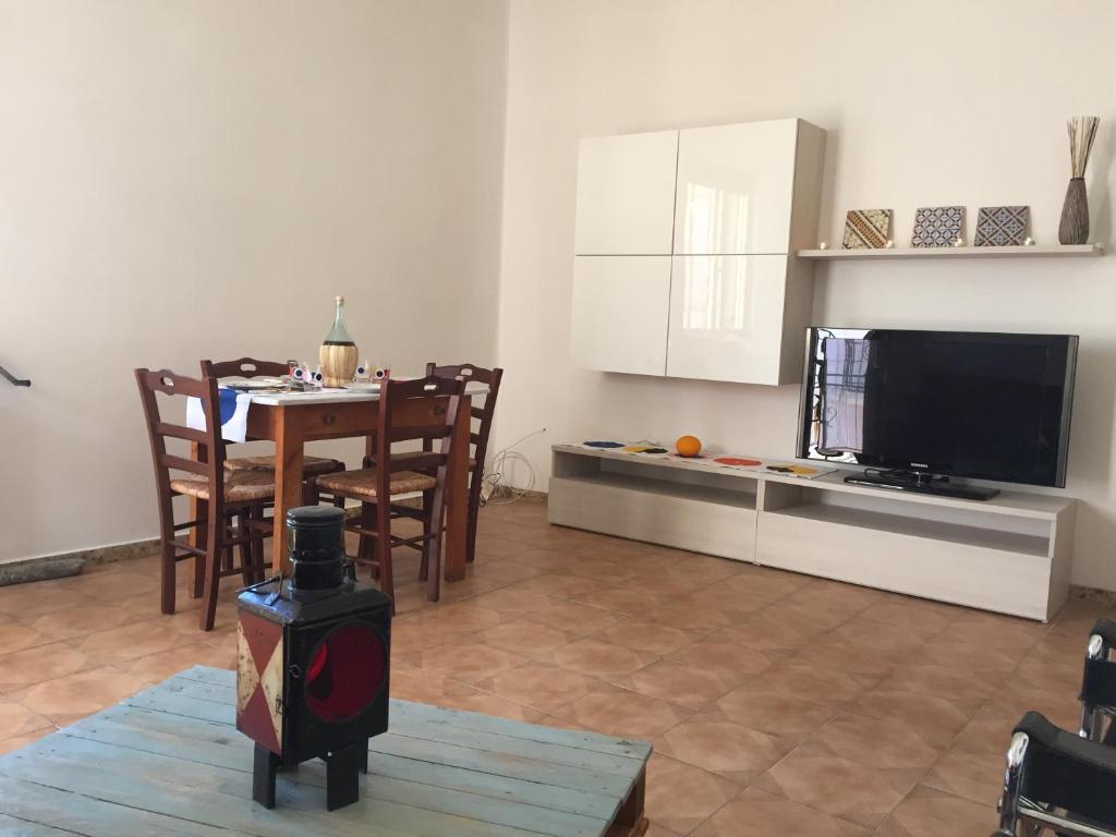 un soggiorno con tavolo e una cucina con TV di Casa Vacanza CIVICO 33 a Marittima
