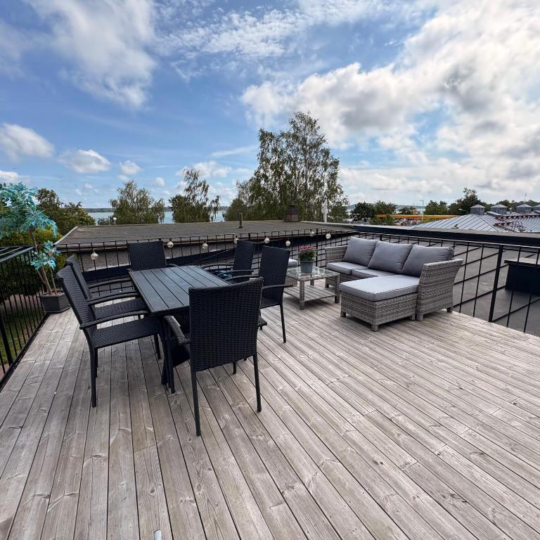 a deck with a table and chairs and a couch at Seaview apartment in Mariehamn