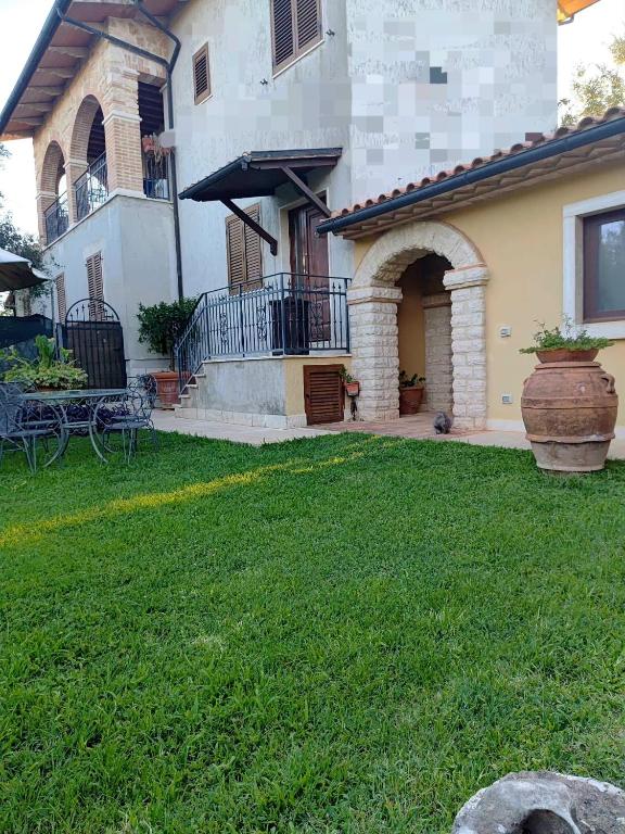 a house with a green yard with a yard at Agriturismo la Canonica in Manciano