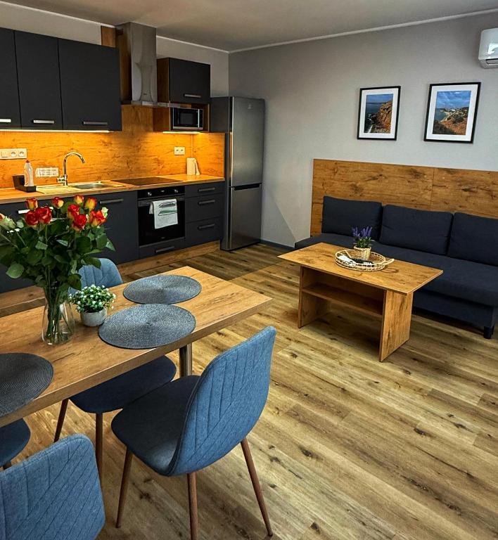 a kitchen and living room with a table and chairs at Garden Apartments in Kráľovský Chlmec