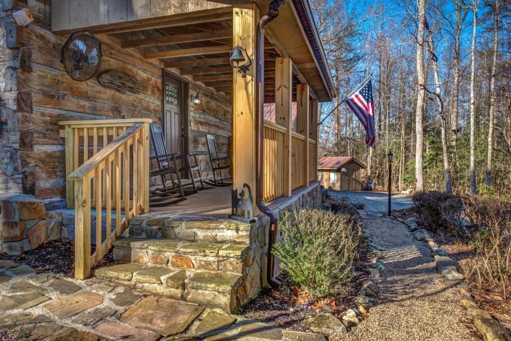 a house with a porch with a flag on it at Cricket Hollow Lodge in Jenkins Mill