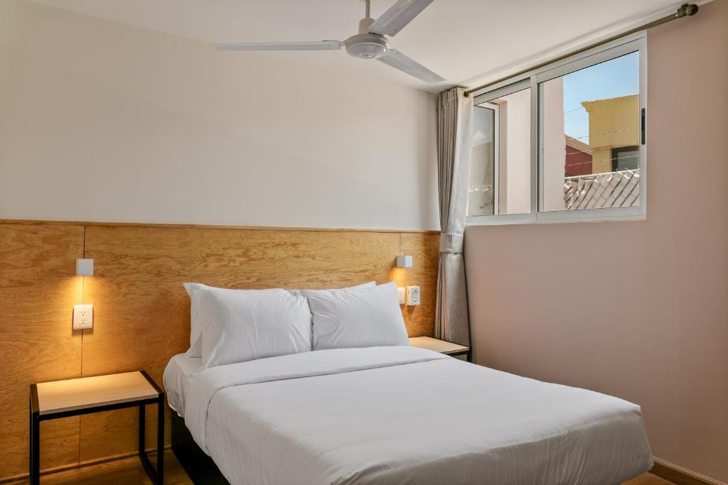 a bedroom with a white bed and a window at Ezequiel Montes By Homirent in Casa Blanca La Corregidora