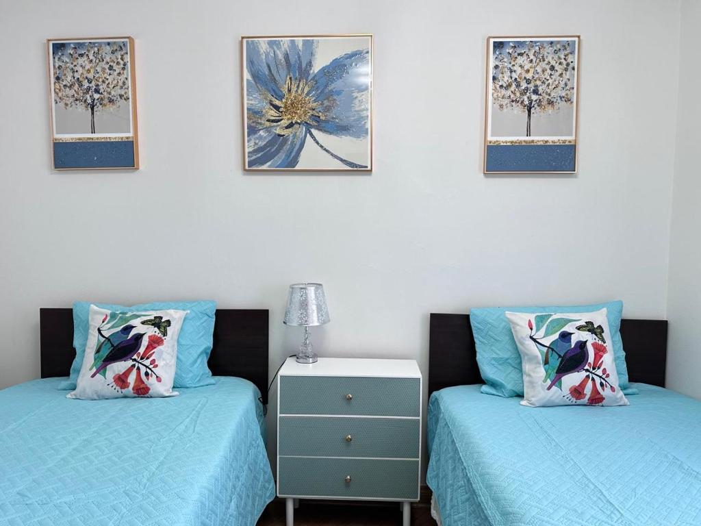 two beds in a room with blue sheets and a table at Apartment Mukarram in Santiago