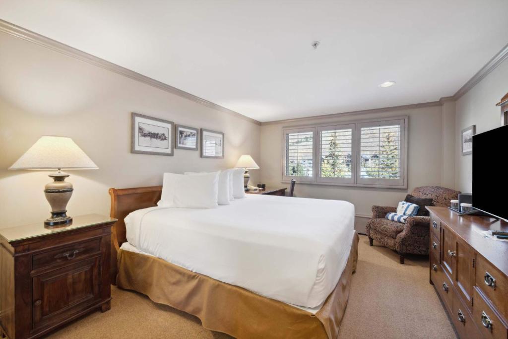 a bedroom with a large white bed and a chair at Lodge Tower 482 in Vail