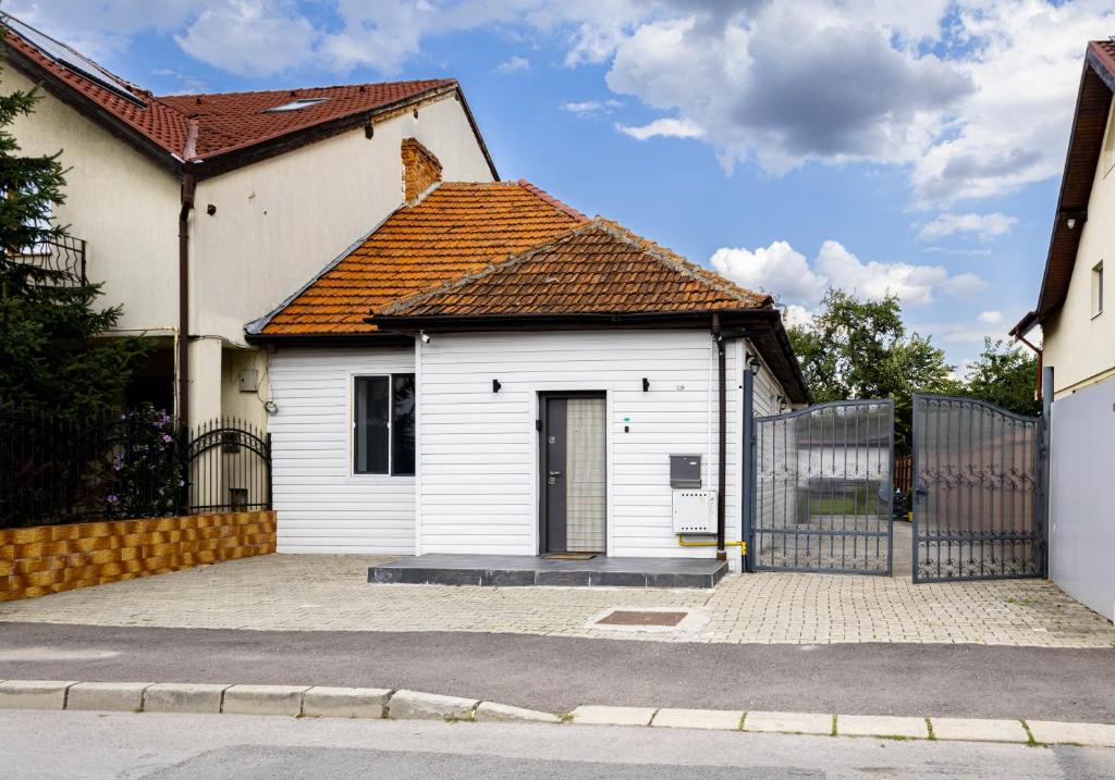 a white house with a gate and a fence at Nordic Villa Brasov - With Private Yard, BBQ & Free Parking, 4 km from City Center in Braşov