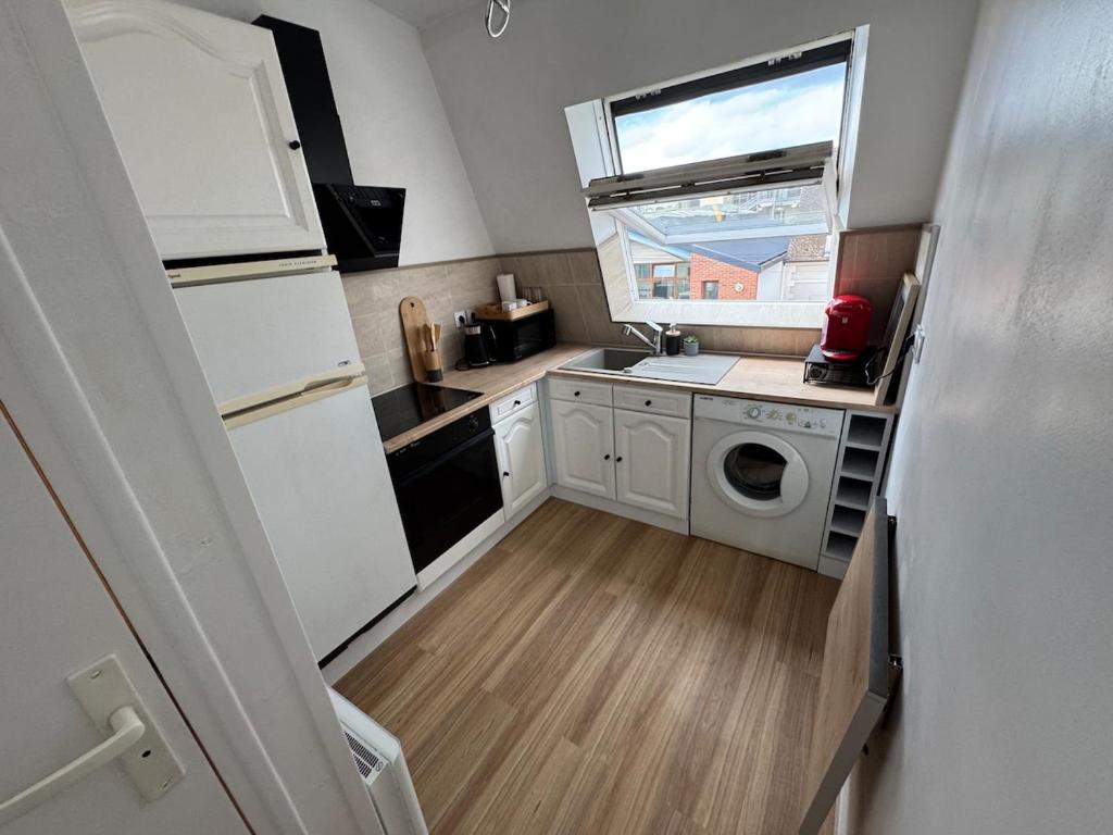 a small kitchen with a refrigerator and a washer and dryer at Studio cosy proche de Paris in Drancy