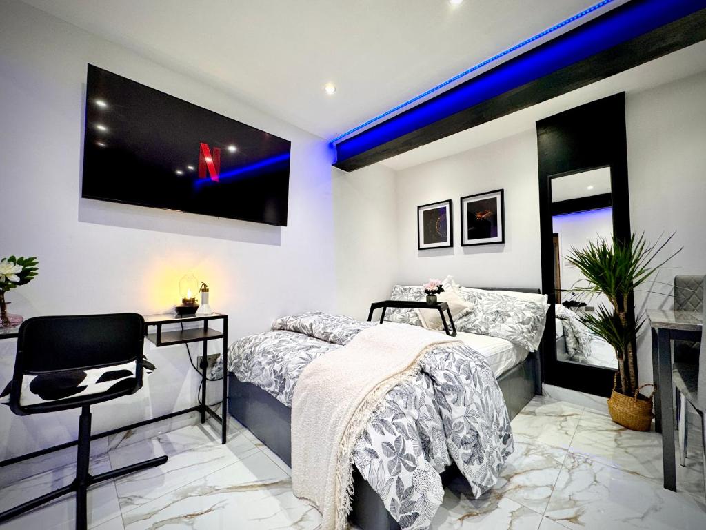 a bedroom with two beds and a flat screen tv at Gorgeous Holiday Home 5 minutes from Central London in London