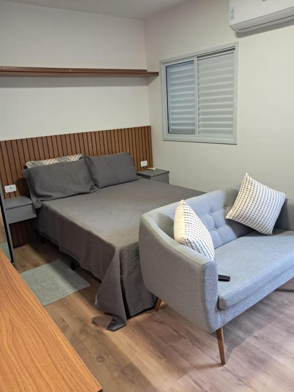 a bedroom with a bed and a couch at Studio de 29m2-SANTANA in Sao Paulo