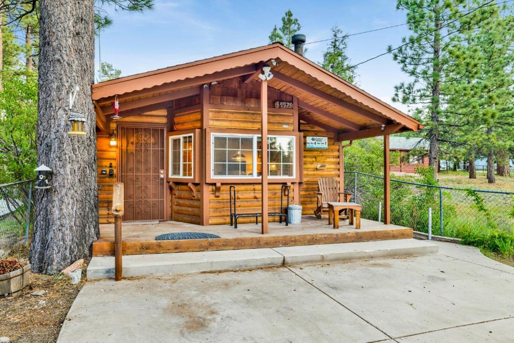 eine Blockhütte mit einer Veranda und einem Baum in der Unterkunft Orchard Family Cabin #2560 in Big Bear Lake