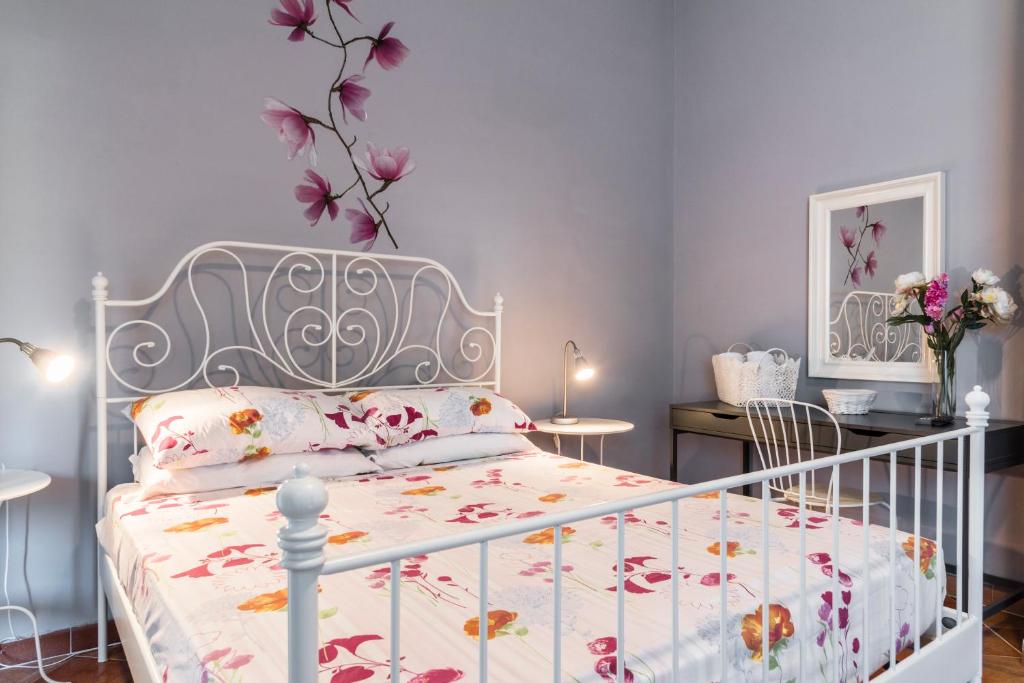 カステッラバーテにあるB&B La Magnoliaのベッドルーム1室(花の壁に白いベッド1台付)