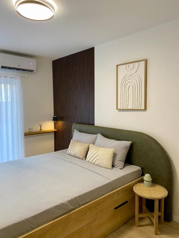a bedroom with a large bed with a green headboard at Studio8 centerapartment Prizren in Prizren