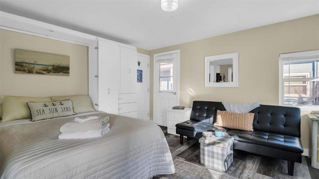 a bedroom with a large bed and a couch at Sunlit Condo Heated Pool across from Beach in Clearwater Beach