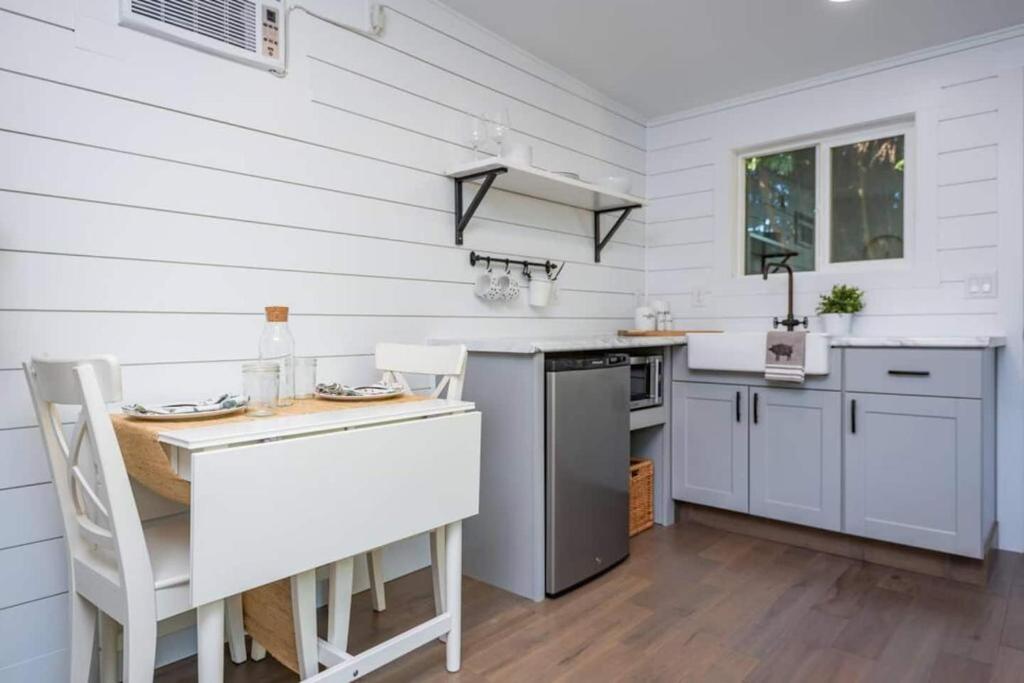a kitchen with white walls and a table and chairs at Private Escape! Tiny home style in Camas