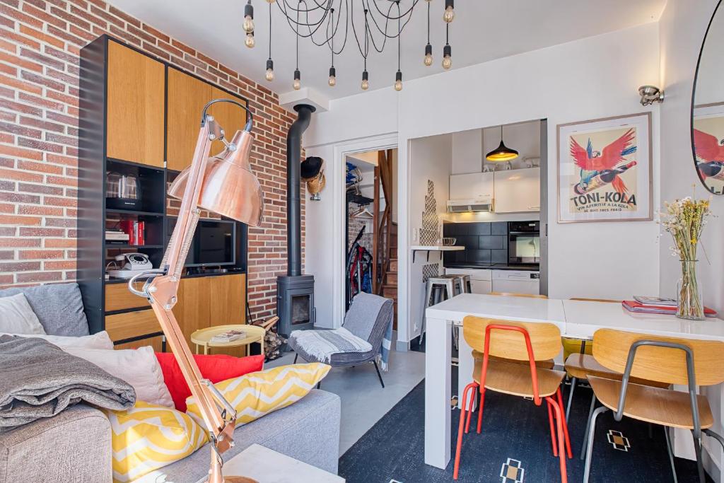 a living room and dining room with a brick wall at Maison typique Trouville, idéale famille in Trouville-sur-Mer