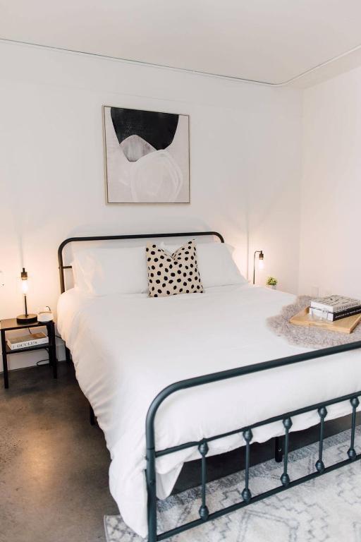 a bedroom with a white bed with a metal frame at <THE MYLO> Walkable | Rooftop | Skyline | Dreamy in Atlanta