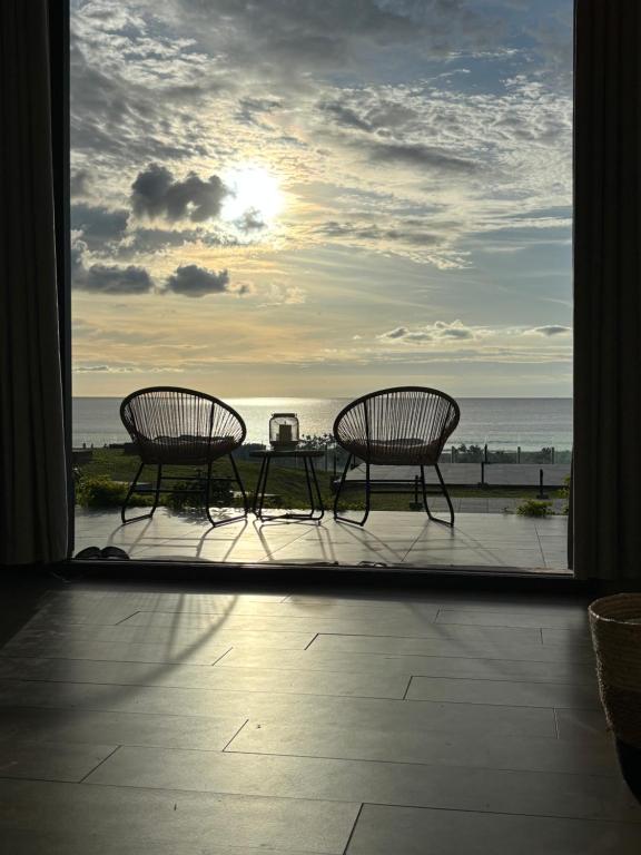 two chairs and a table on a balcony with the ocean at Stunning Oceanview 2B Waterfront Apartement in Bijilo