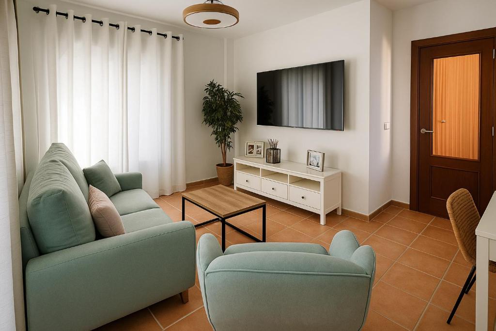 a living room with a couch and a tv at El Balcón de Fuenteheridos in Fuenteheridos