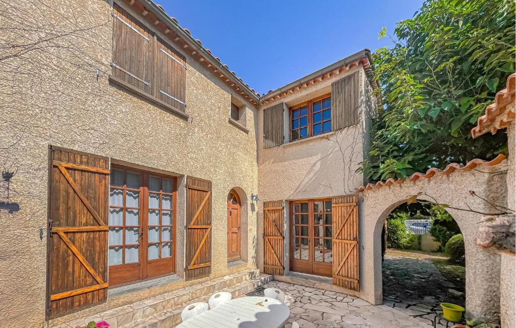 a building with wooden doors and an archway at Villa Proche Cévennes in Saint-Hilaire-de-Brethmas