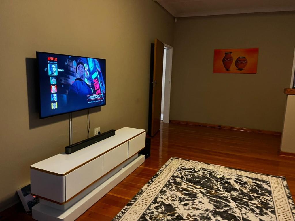 a living room with a flat screen tv on a wall at Goshen in Johannesburg