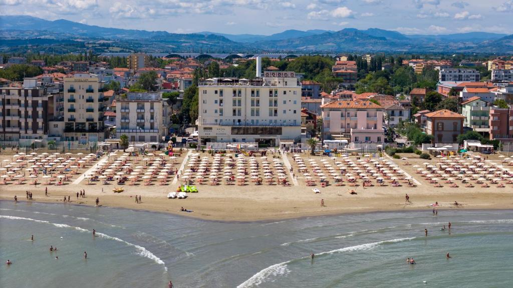 a beach with umbrellas and people on the beach at Hotel Blumen in Rimini