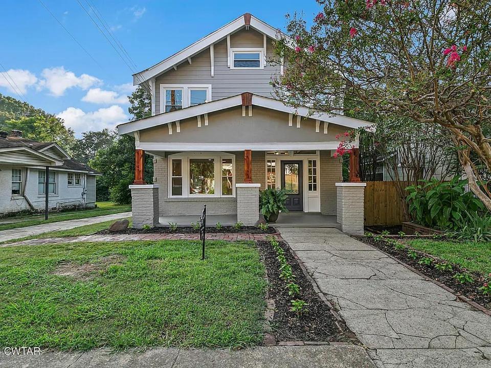 a white house with a driveway in front of it at Campbell Street Charm in Jackson