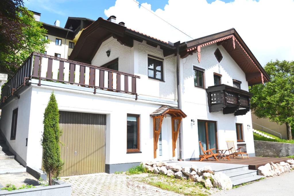 a white house with a balcony and a garage at Bad Ischl - Central & Quiet Apartment in Bad Ischl