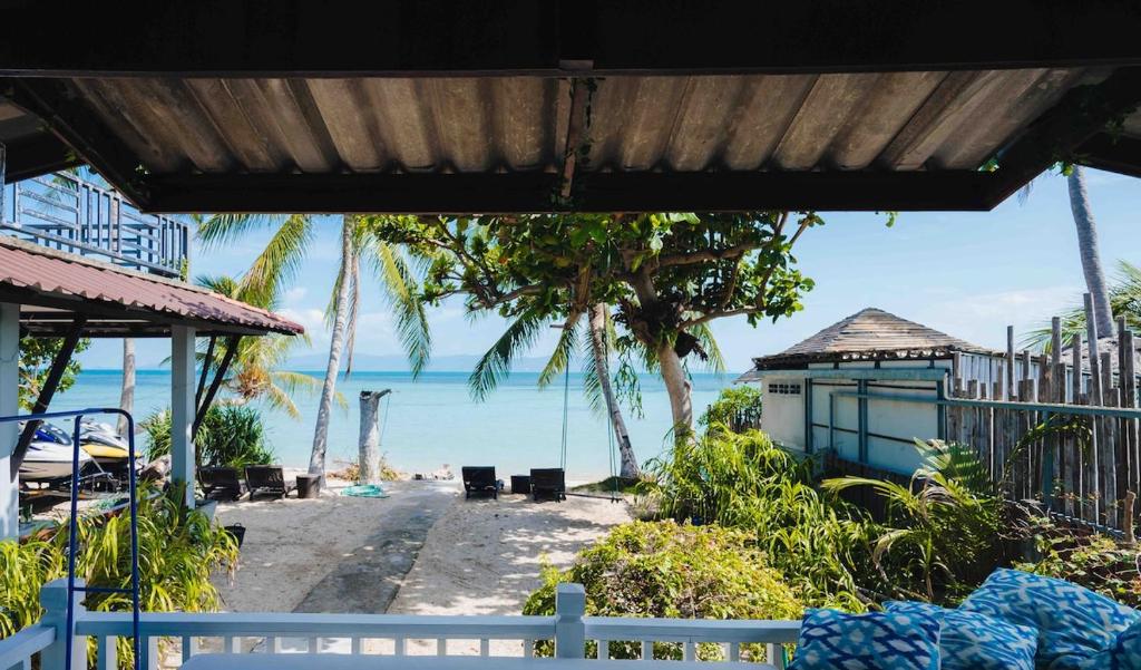 a view of a beach with palm trees and the ocean at Sunset Dream Beach Front House in Thong Sala