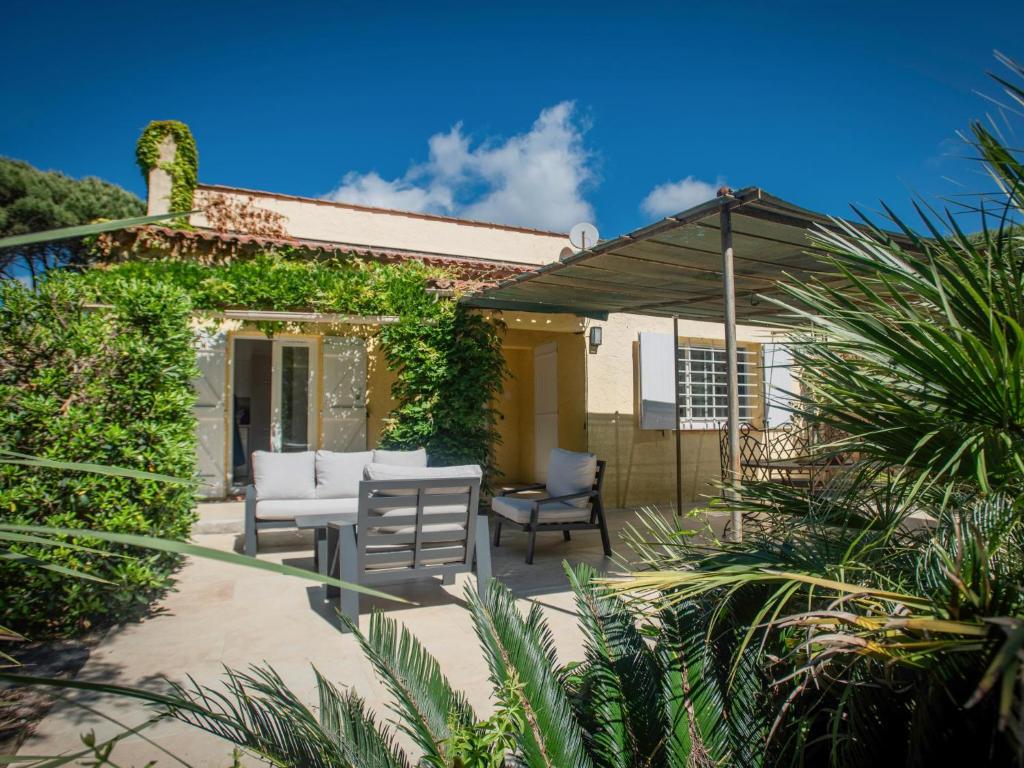 un patio avec une table et des chaises et un bâtiment dans l'établissement Les Romarins, à Saint-Tropez