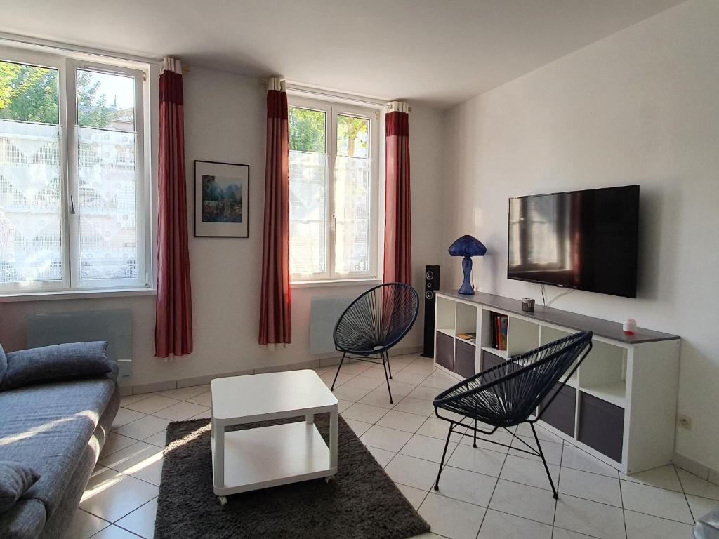 Una sala de estar con un sofá y un televisor. en City Break en centre-ville, proche commodités et sites naturels - FR-1-585-77, en Bar-le-Duc