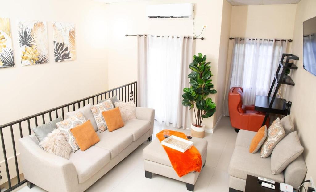 a living room with a couch and a chair at Stacys Place #2 2 Bedroom Apartment in Port-of-Spain