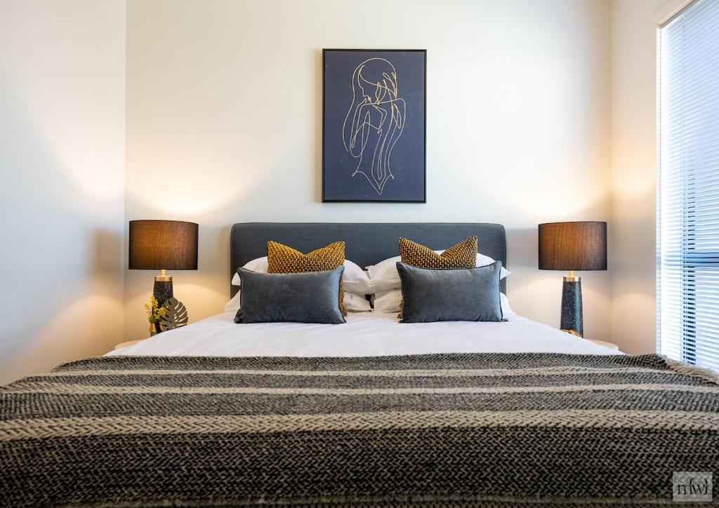 Un dormitorio con una cama grande con dos lámparas. en Golden Retreat - Couples Getaway Business stay, en Golden Square