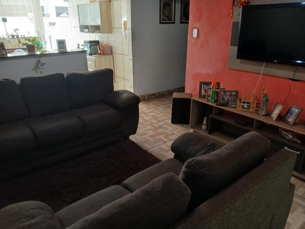 a living room with a couch and a flat screen tv at Casa Festa do Peão Barretos in Barretos