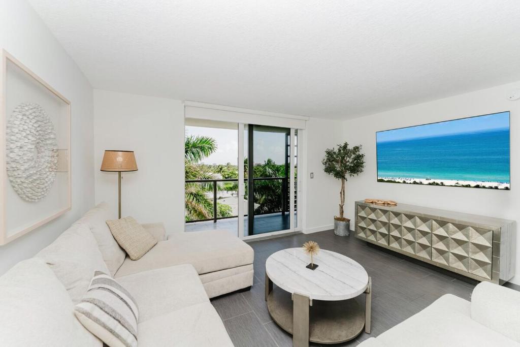 a living room with a white couch and a table at Prime Beach and Golf Retreat 2BR Pool & Balcony in Boca Raton