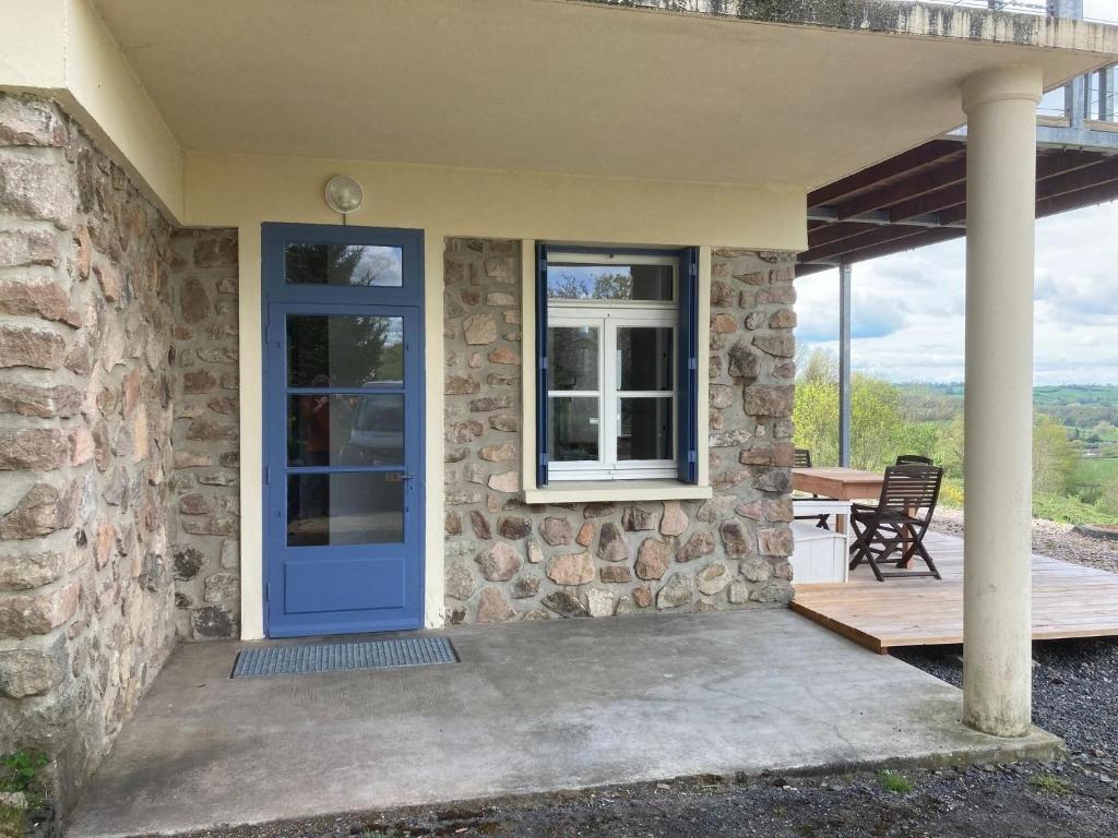 a stone house with a blue door and a patio at Apartment in Cuzy with Heated Pool in Cuzy