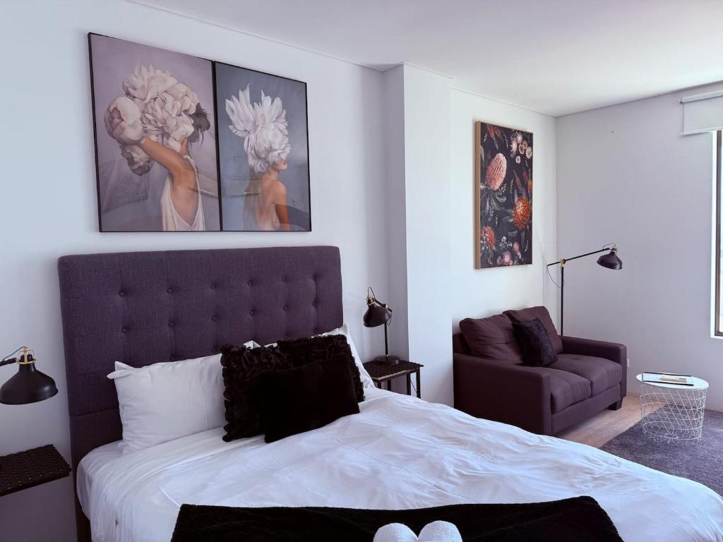 a bedroom with a large bed and a couch at 806 Deluxe Delight Concert Hall Studio in Perth