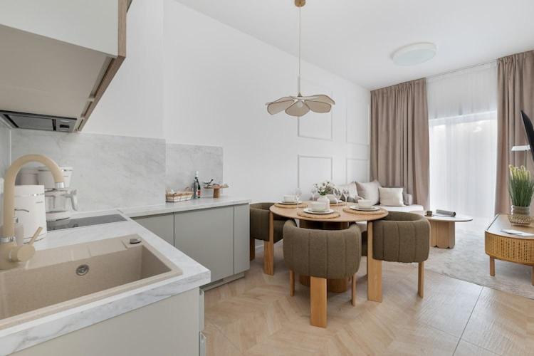 a kitchen and living room with a table and a sink at Apartment, indoor pool, Pobierowo in Pobierowo