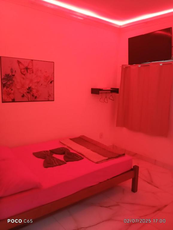 マンガラチバにあるPousada suite Praiaの赤いカーテン付きのベッドが備わる赤い部屋