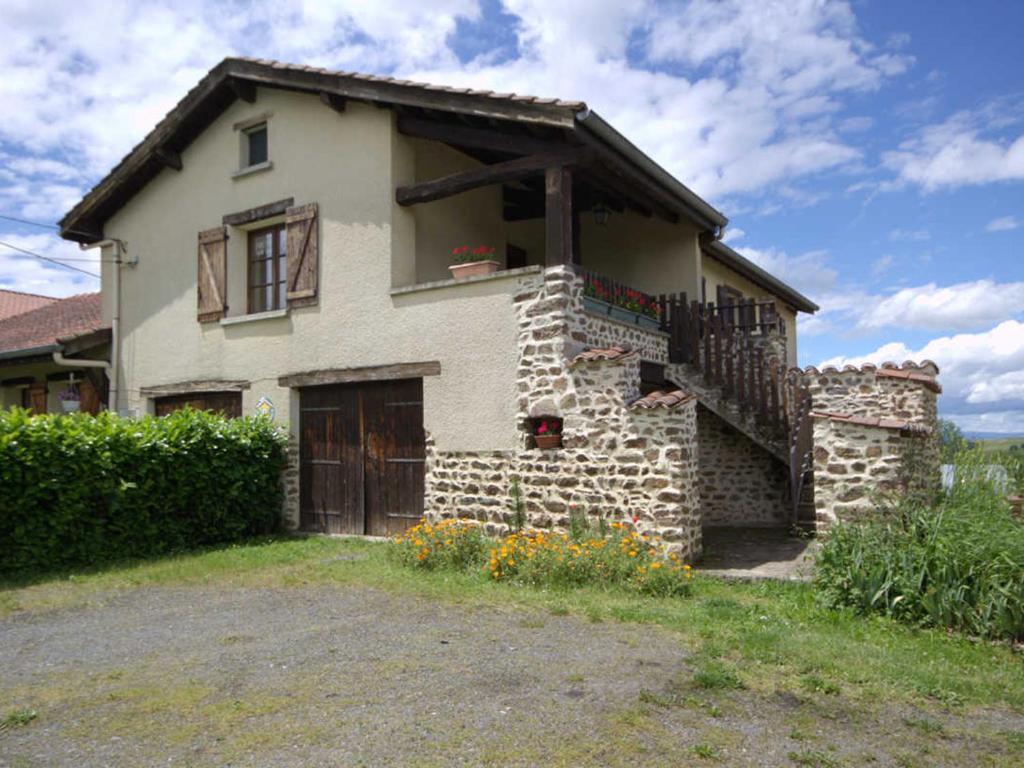 Gîte familial avec jeux extérieurs près de St-Galmier - FR-1-496-281 في Saint-Médard-en-Forez: منزل حجري مع شرفة ودرج