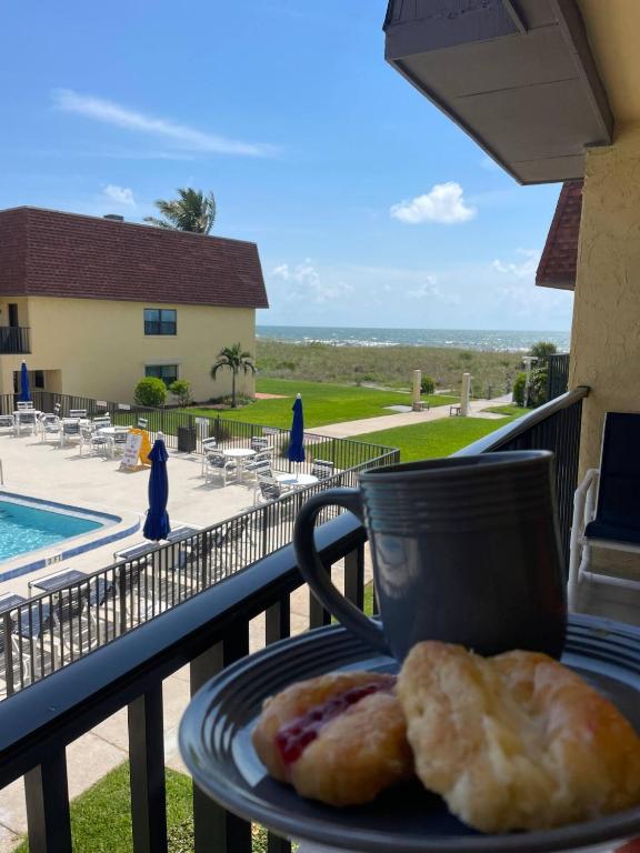 a plate of donuts and a cup of coffee on a table at Beachfront with heated pool, 60 seconds to beach in Cocoa Beach