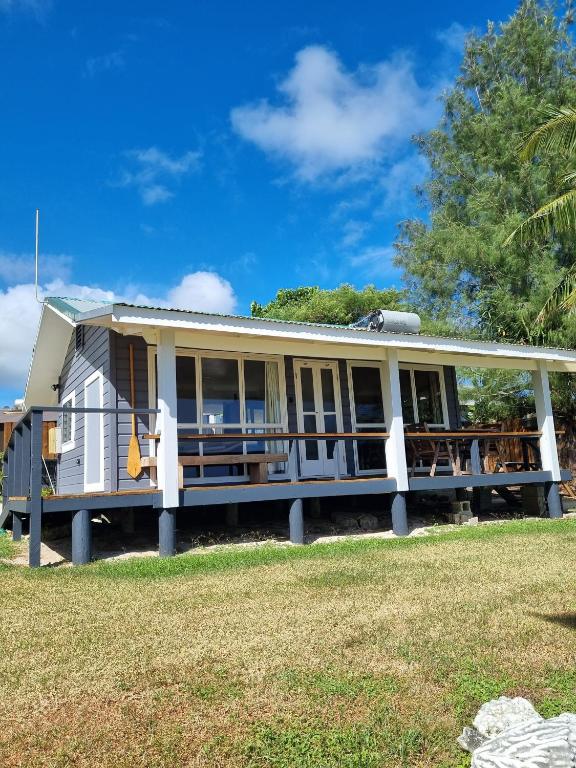 a manufactured home with a porch and a house at Ocean Beach Bach Rarotonga in Rarotonga