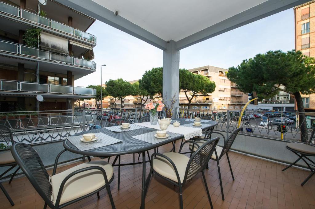 een patio met tafels en stoelen op een balkon bij House Gregorio in Rome