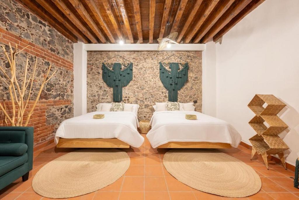 two beds in a room with a wall at DH3 VIP & Luxurious 2beds APT in Historic Center in Mexico City