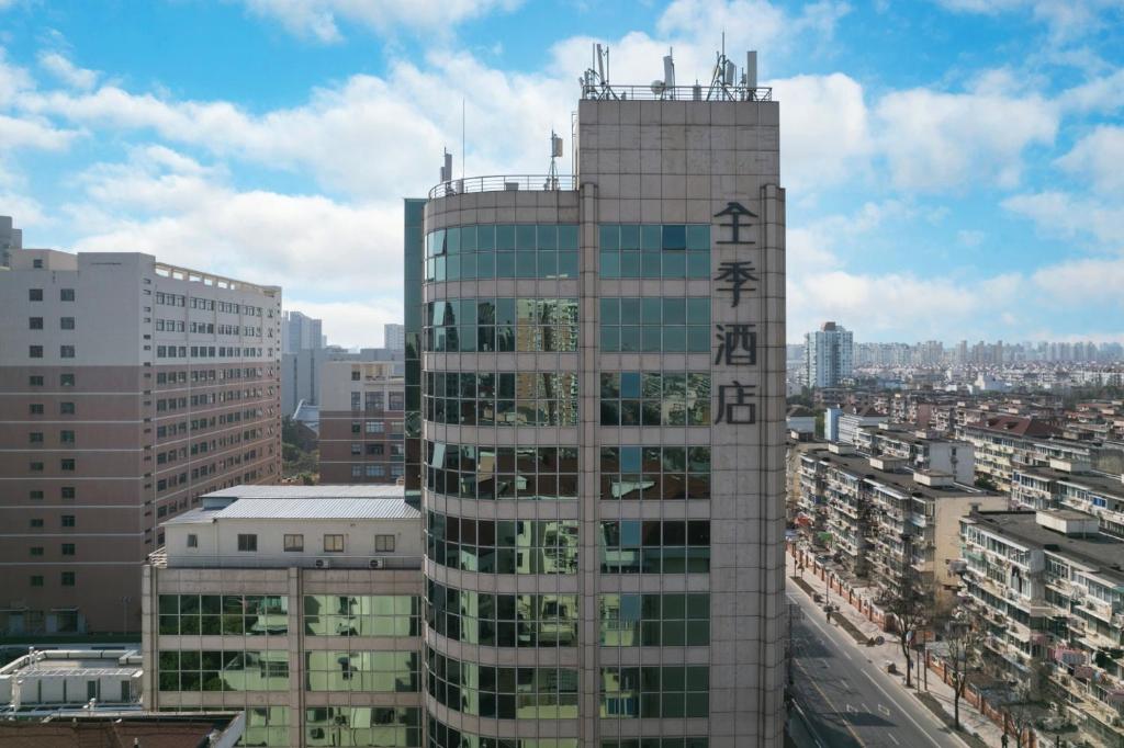 JI Hotel Shanghai Wujiaochang Changhai Hospital في شانغهاي: مبنى مرتفع مع لافتة في أعلاه