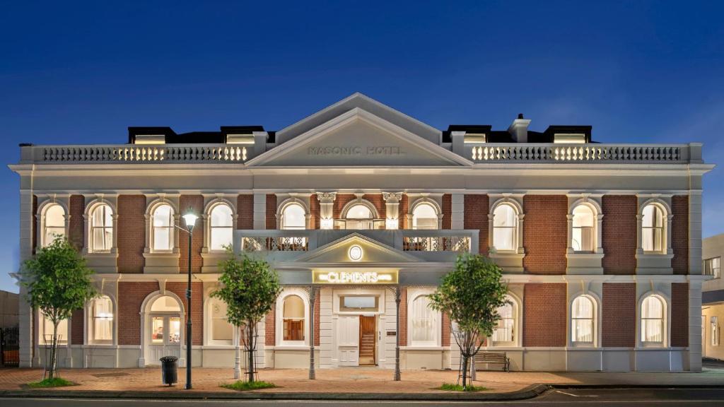 a large brick building with trees in front of it at The Clements Hotel in Cambridge