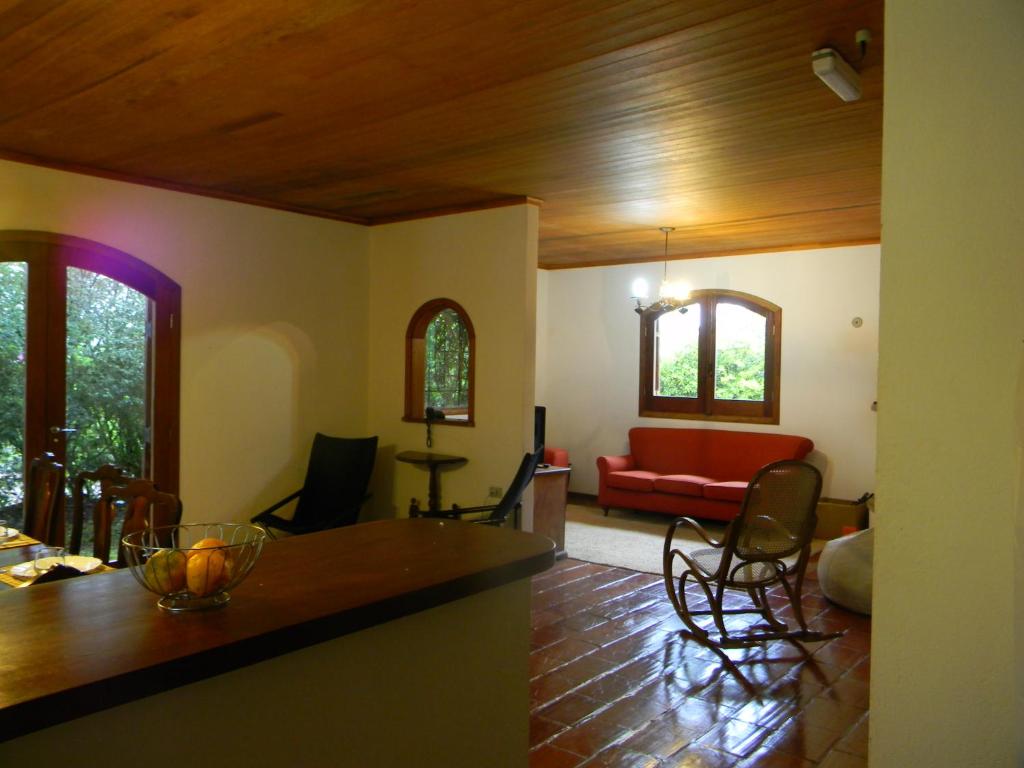 a living room with a red couch and a table at Casa do sol in Monte Verde